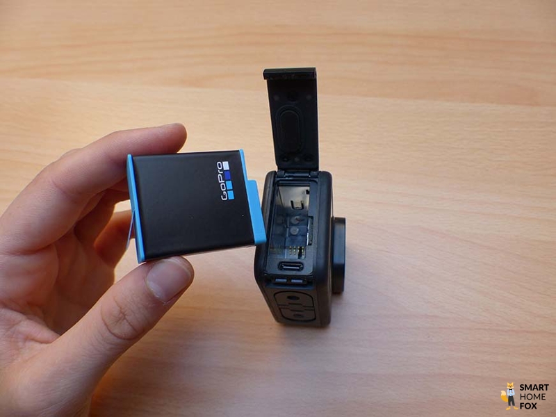 Man sieht, wie der Akku aus der GoPro Hero 9 herausgenommen wird.